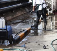 Staff wash floors with high-pressure machines